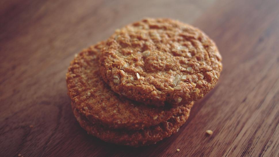 Free Image of Oatmeal cookies stacked on wooden surface 