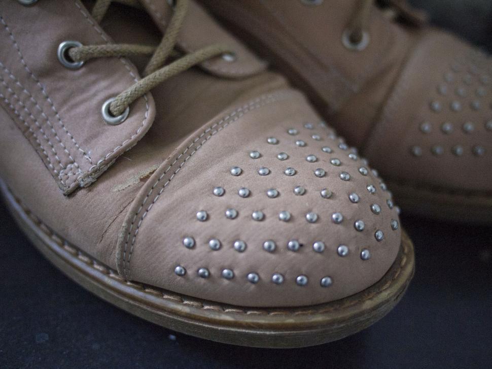 Free Image of Close-up of studded leather shoes on pavement 