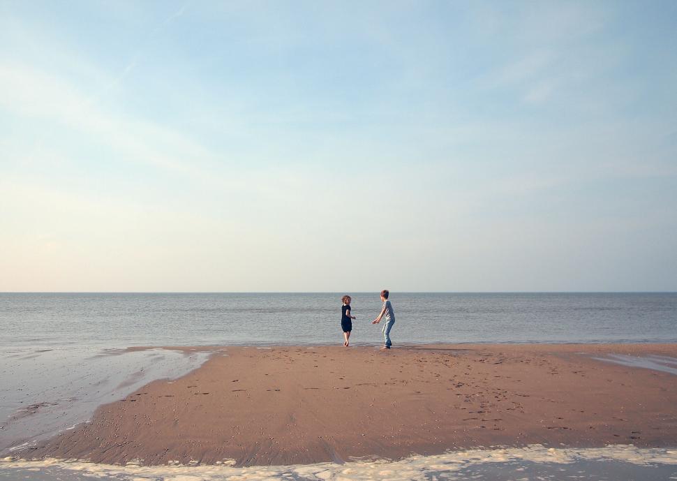 Free Image of Two children playing on a tranquil beach 
