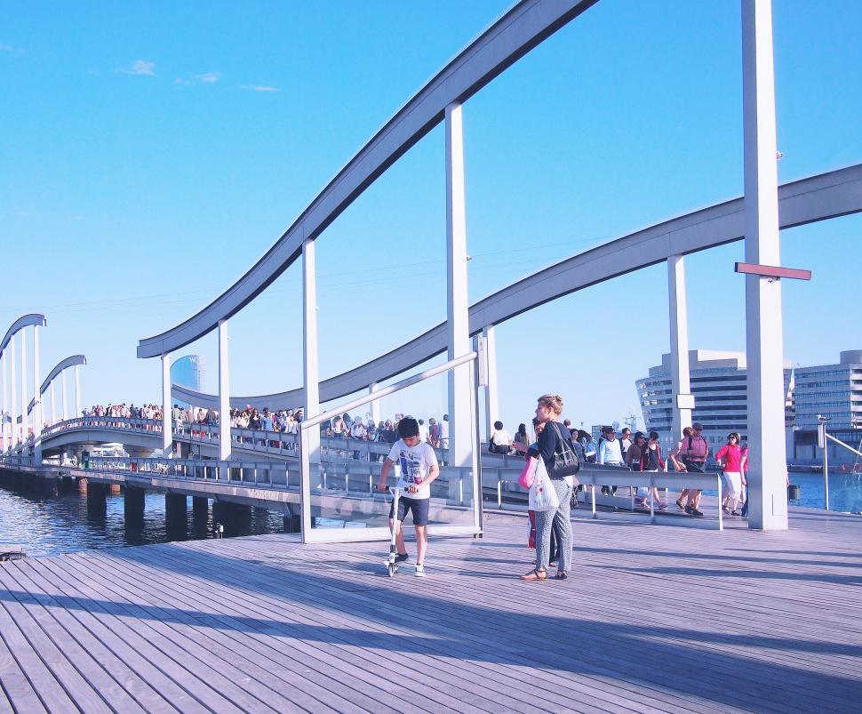 Free Image of Waterfront walkway with people and modern architecture 