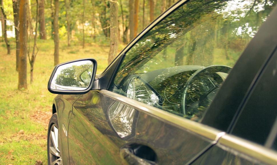 Free Image of Car side mirror view with forest reflection 