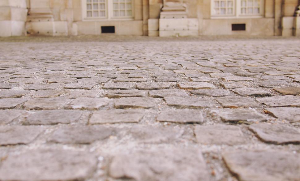 Free Image of Paved cobblestone street in front of classical architecture 