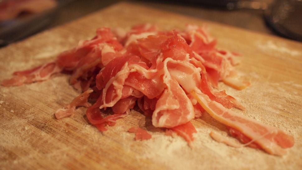 Free Image of Freshly sliced prosciutto on a wooden board 
