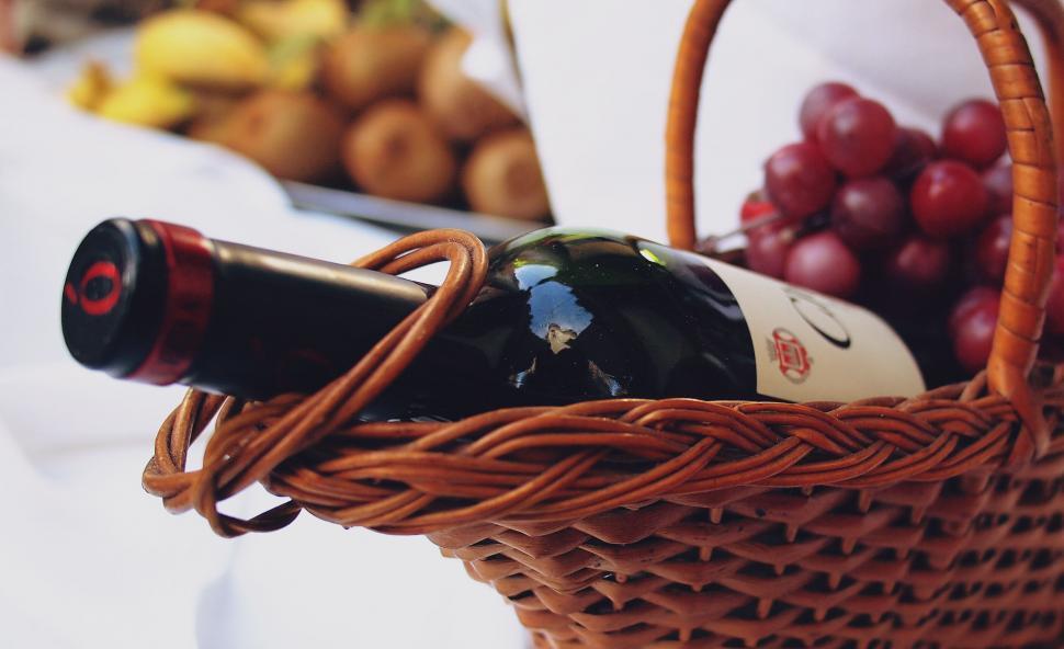 Free Image of Closeup of a wine bottle in a picnic basket 