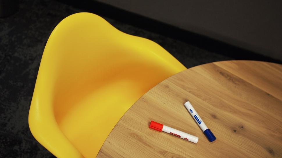 Free Image of Yellow chair and white table with markers 