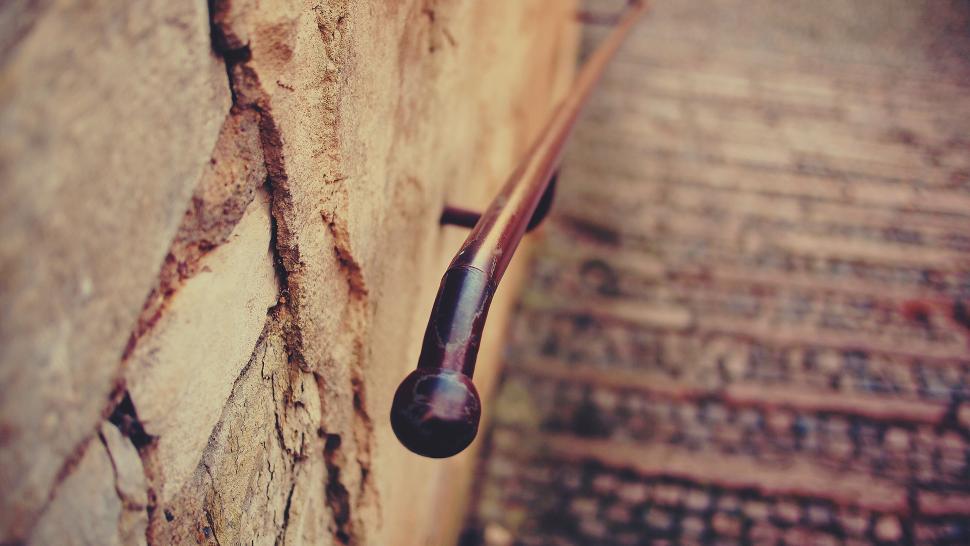 Free Image of Rusty pipe protruding from aged brick wall 