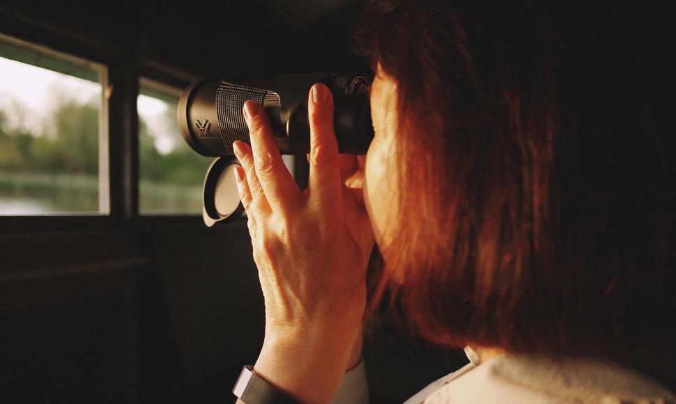 Free Image of Woman looking through binoculars on a train 