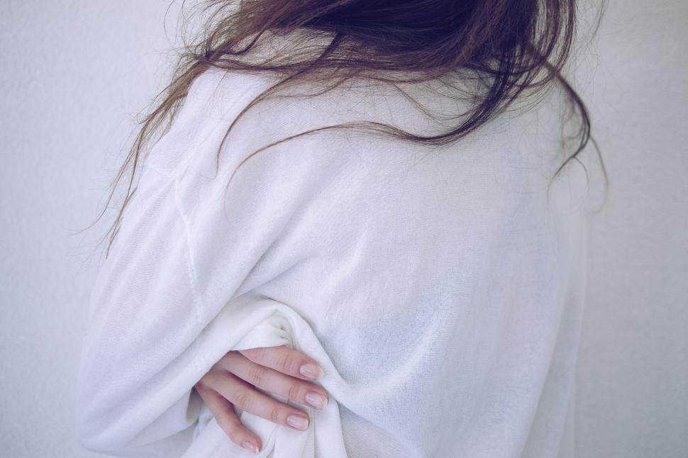 Free Image of Woman clutching white shirt from behind 
