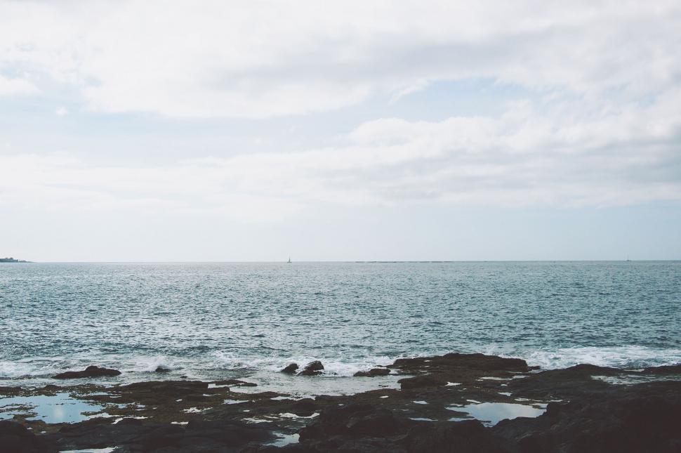 Free Image of Tranquil ocean view with rocky foreground 