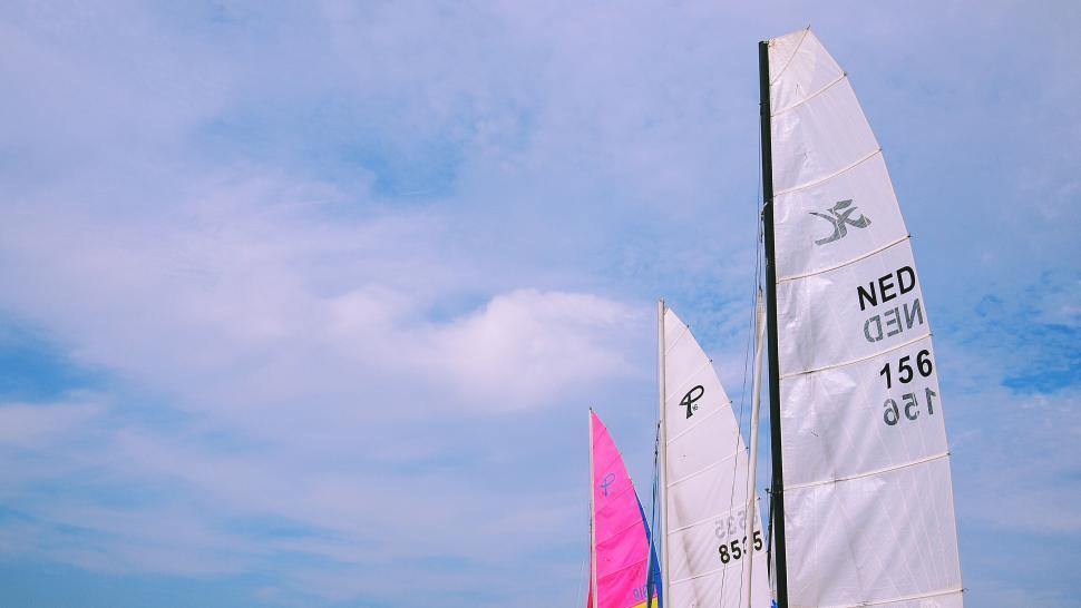Free Image of Sailing boats with colorful sails on blue sky 