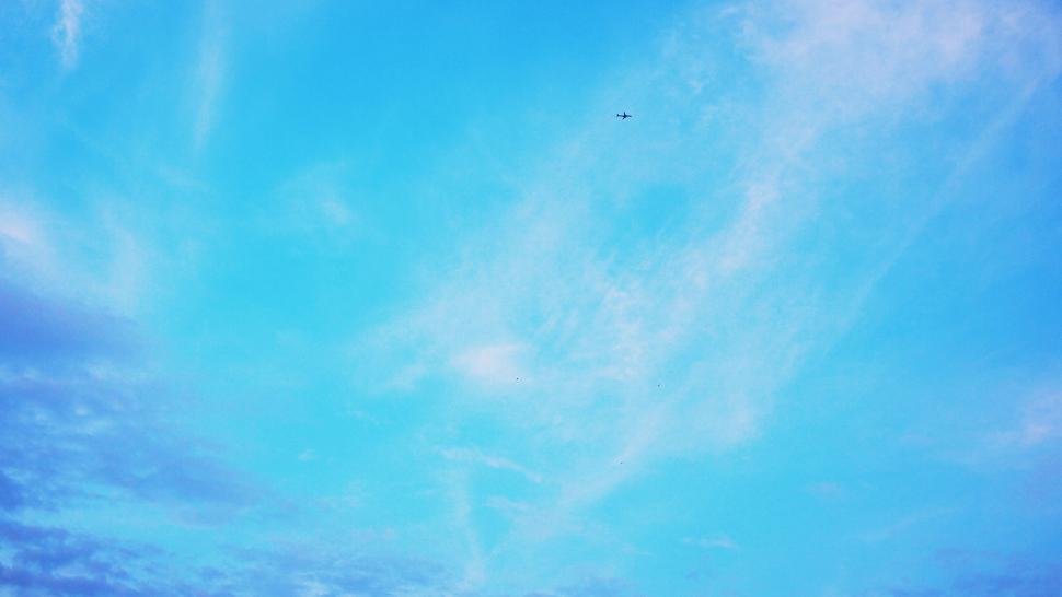 Free Image of Vast blue sky with subtle clouds and tiny plane 