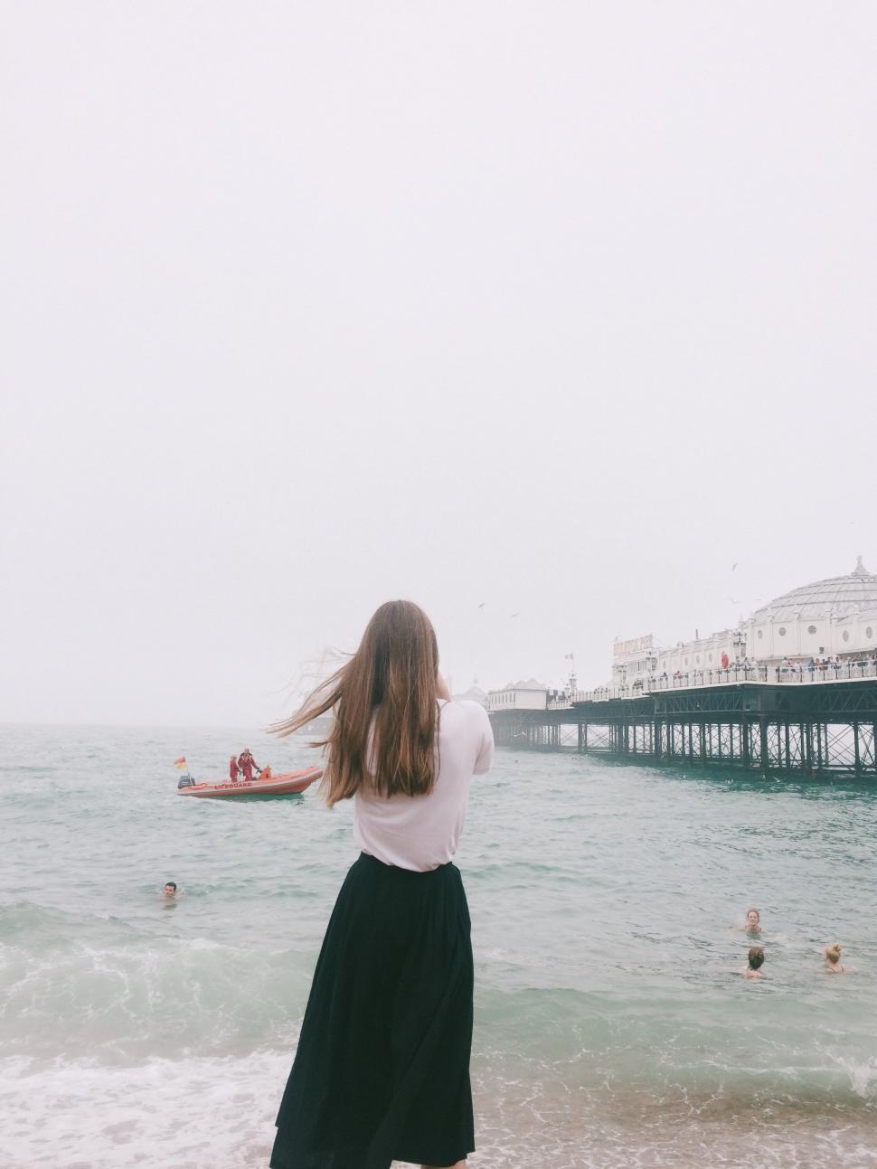 Free Image of Woman looking at a seaside pier 