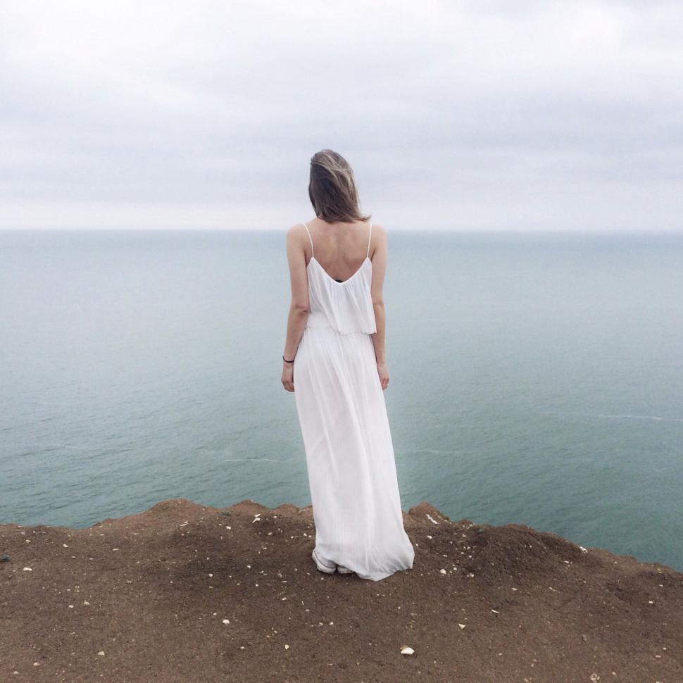 Free Image of Woman wearing white at cliff edge 