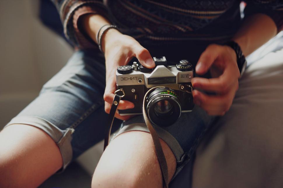 Free Image of Person holding a vintage camera on their lap 