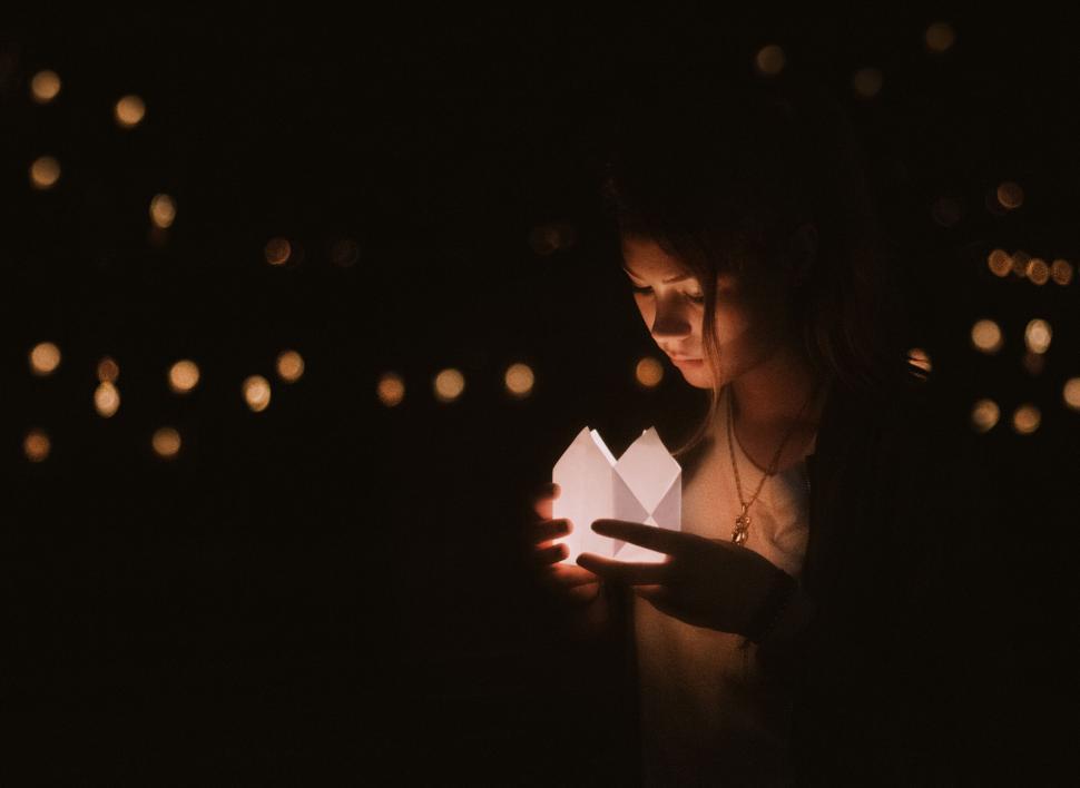 Free Image of Person holding a paper heart with lights around 