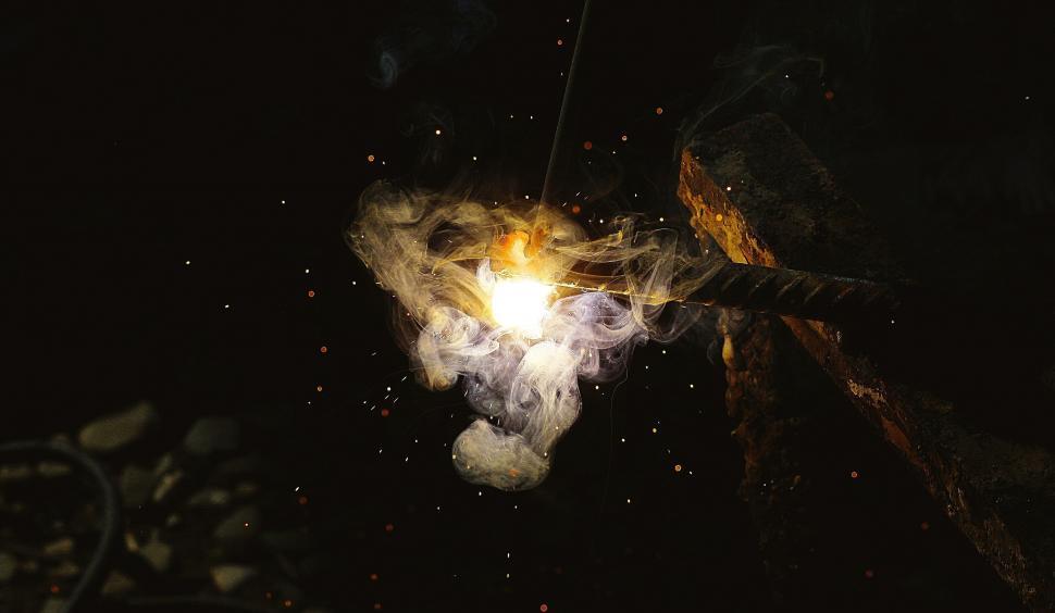 Free Image of Sparks flying from welding in the dark 