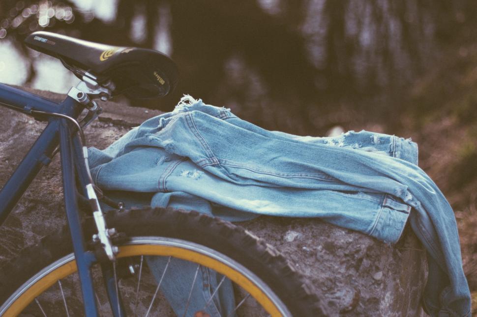 Free Image of Blue jeans draped over a bicycle seat 