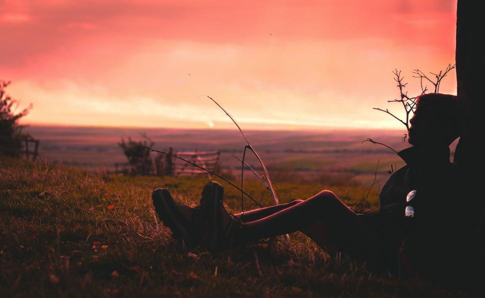 Free Image of Person sitting on grass during sunset 