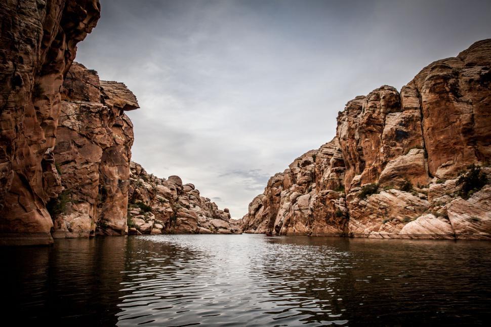 Free Image of Canyon landscape with calm water under cloudy sky 