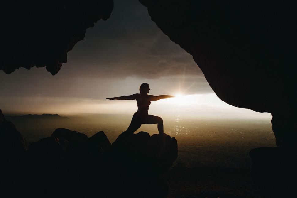 Free Image of Silhouette of a person practicing yoga at sunrise 