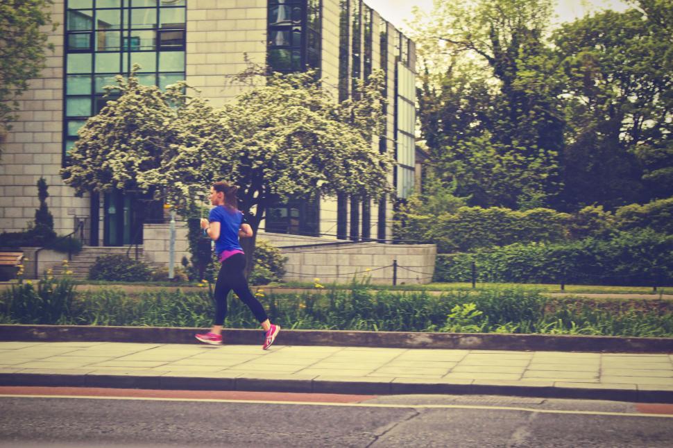 Free Image of Urban runner on city pavement with greenery 