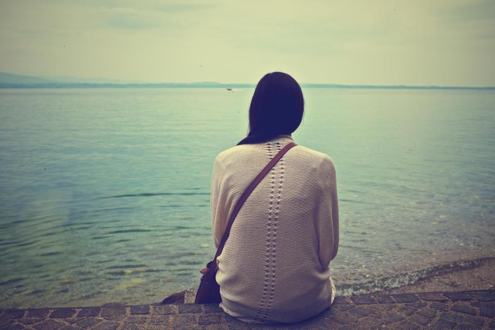 Free Image of Woman gazing at the sea from a pier 