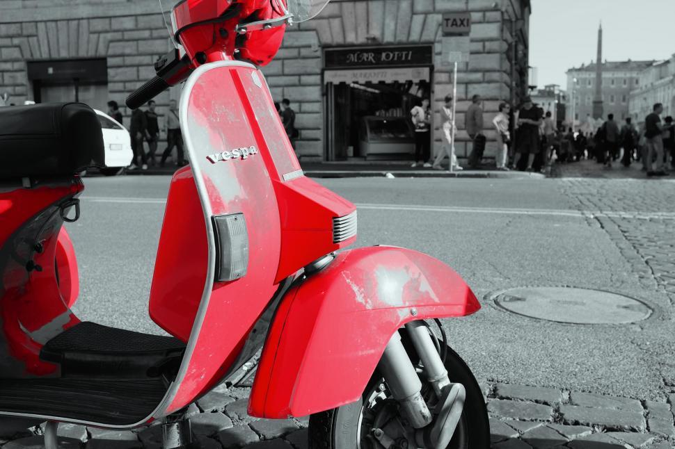 Free Image of Iconic red Vespa scooter on a city street 