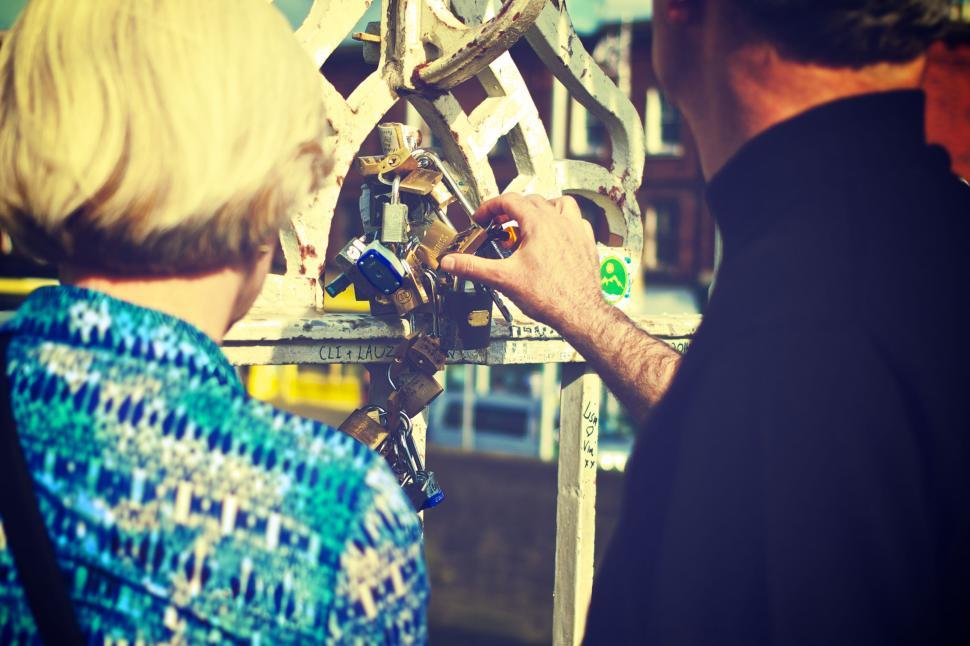 Free Image of Senior couple pointing at lock on bridge 