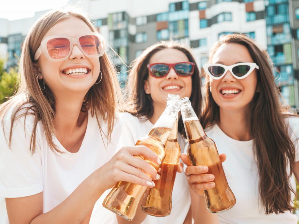 Free Image of A group of women holding bottles of beer 