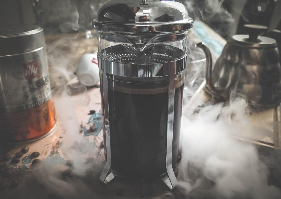 Free Image of Steaming French press amidst coffee cans 