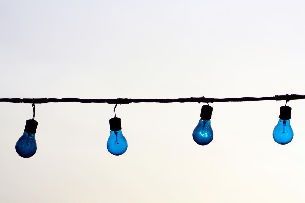 Free Image of Row of blue light bulbs against sky 