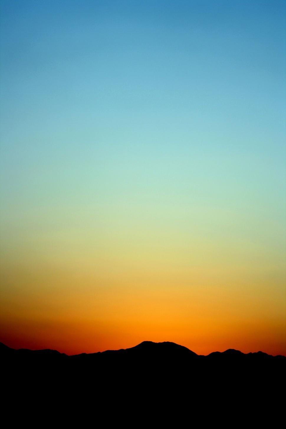 Free Image of Gradient sunset sky over silhouette mountains 