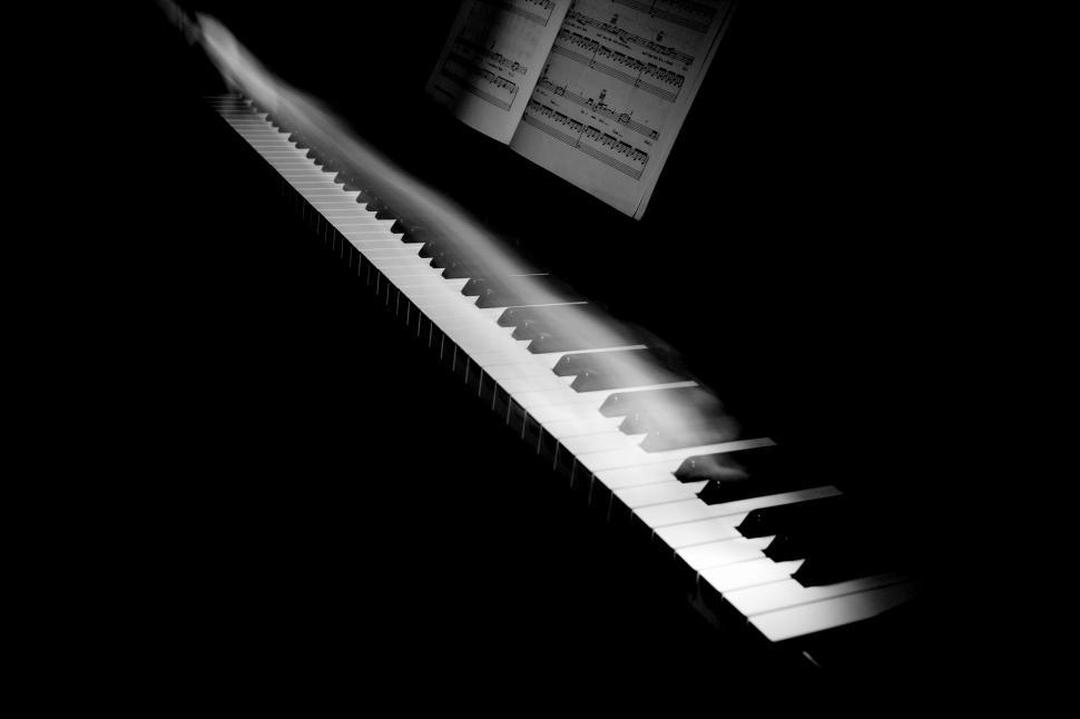 Free Image of Piano keys and sheet music in shadow 