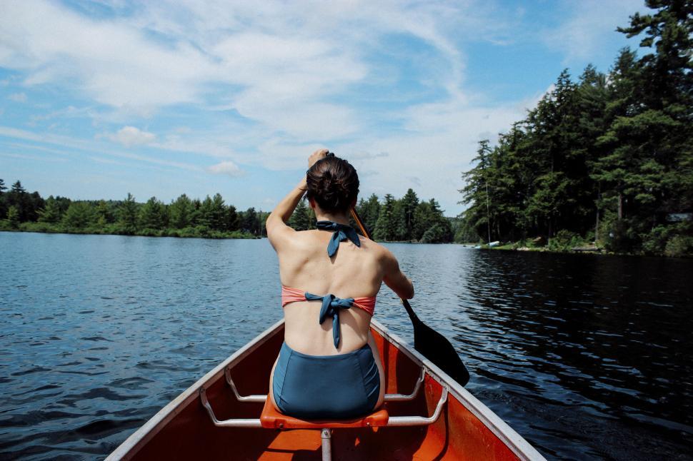 Free Image of Woman canoeing on a scenic lake 