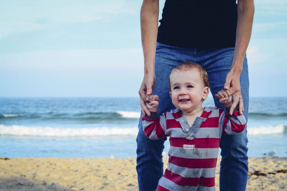 Free Image of Parent holding child s hand at the beach 