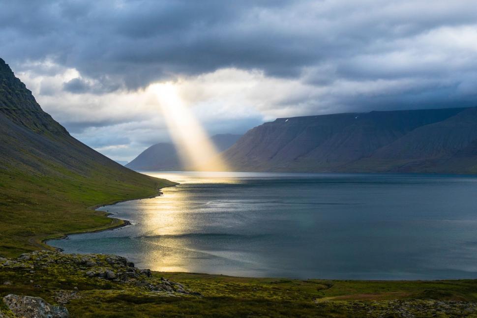 Free Image of Dramatic sunbeam over a serene fjord 