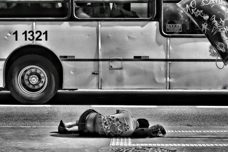 Free Image of Person lying on street near moving bus 