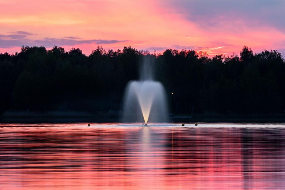 Free Image of Fountain silhouette against a vibrant sunset sky 