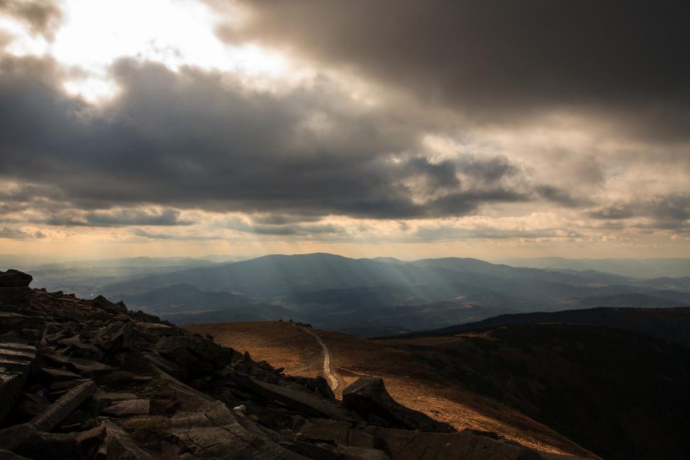 Free Image of Hikers on a mountain trail under a dramatic sky 