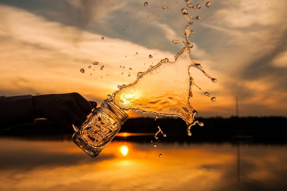 Free Image of Splashing water from glass at sunset 