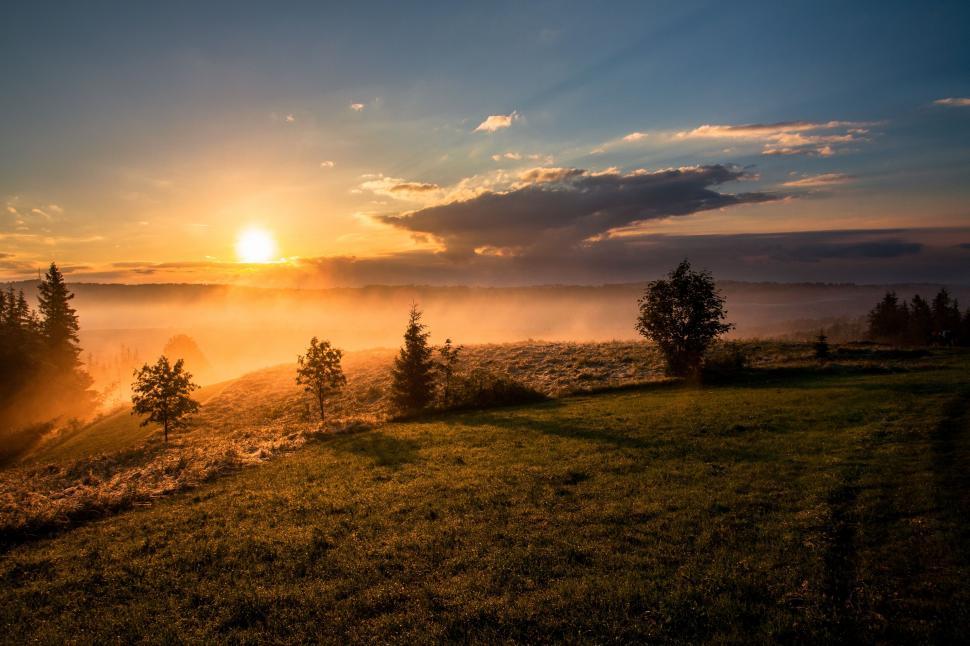Free Image of Sunrise over a foggy countryside landscape 