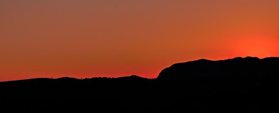 Free Image of Mountain silhouette against a clear sunset sky 