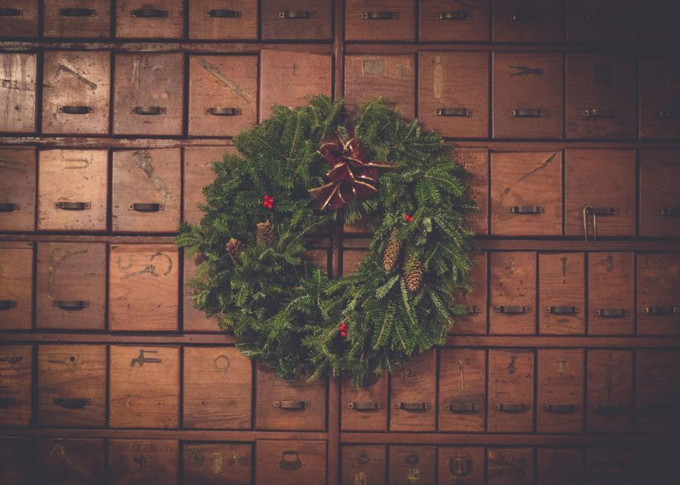 Free Image of Christmas wreath on antique wooden drawers 