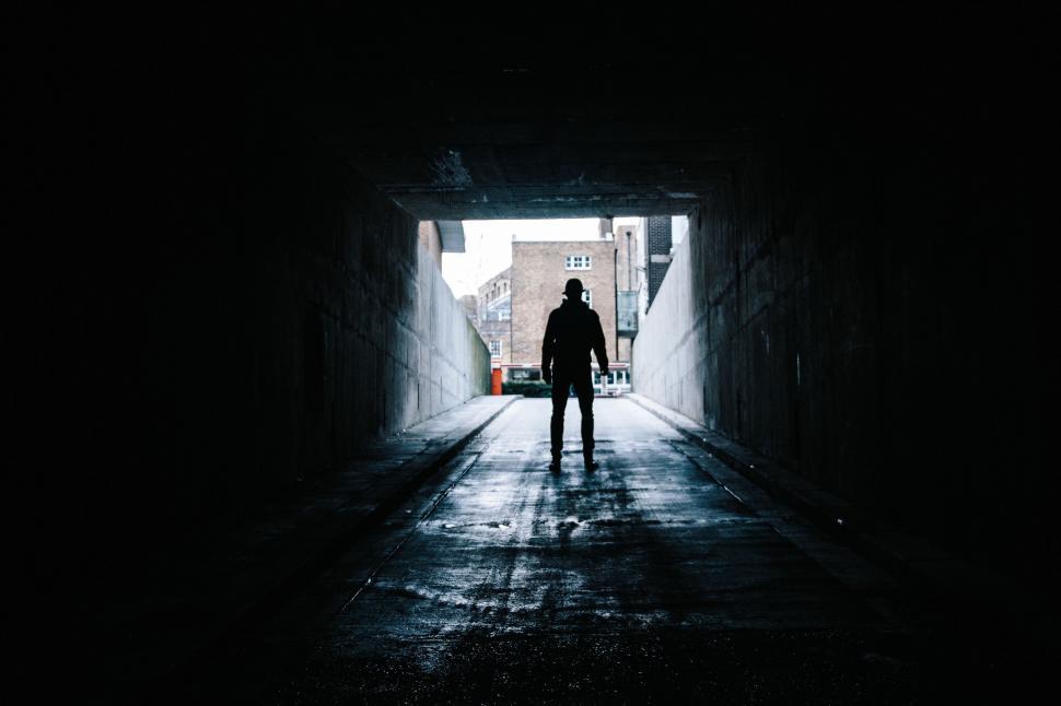 Free Image of Silhouetted figure standing in a tunnel 