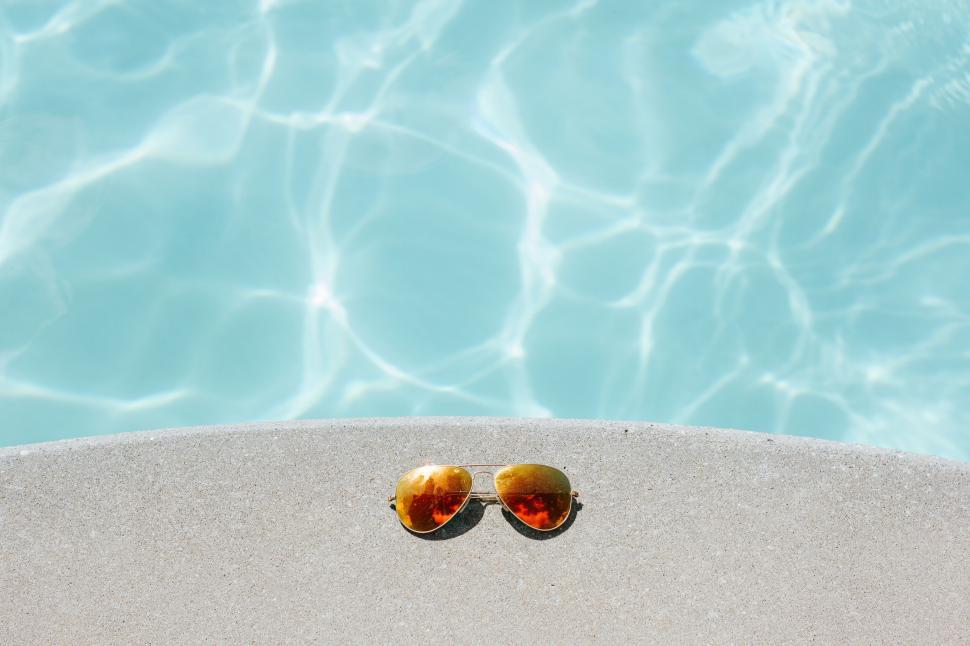 Free Image of Sunglasses by the poolside on a sunny day 