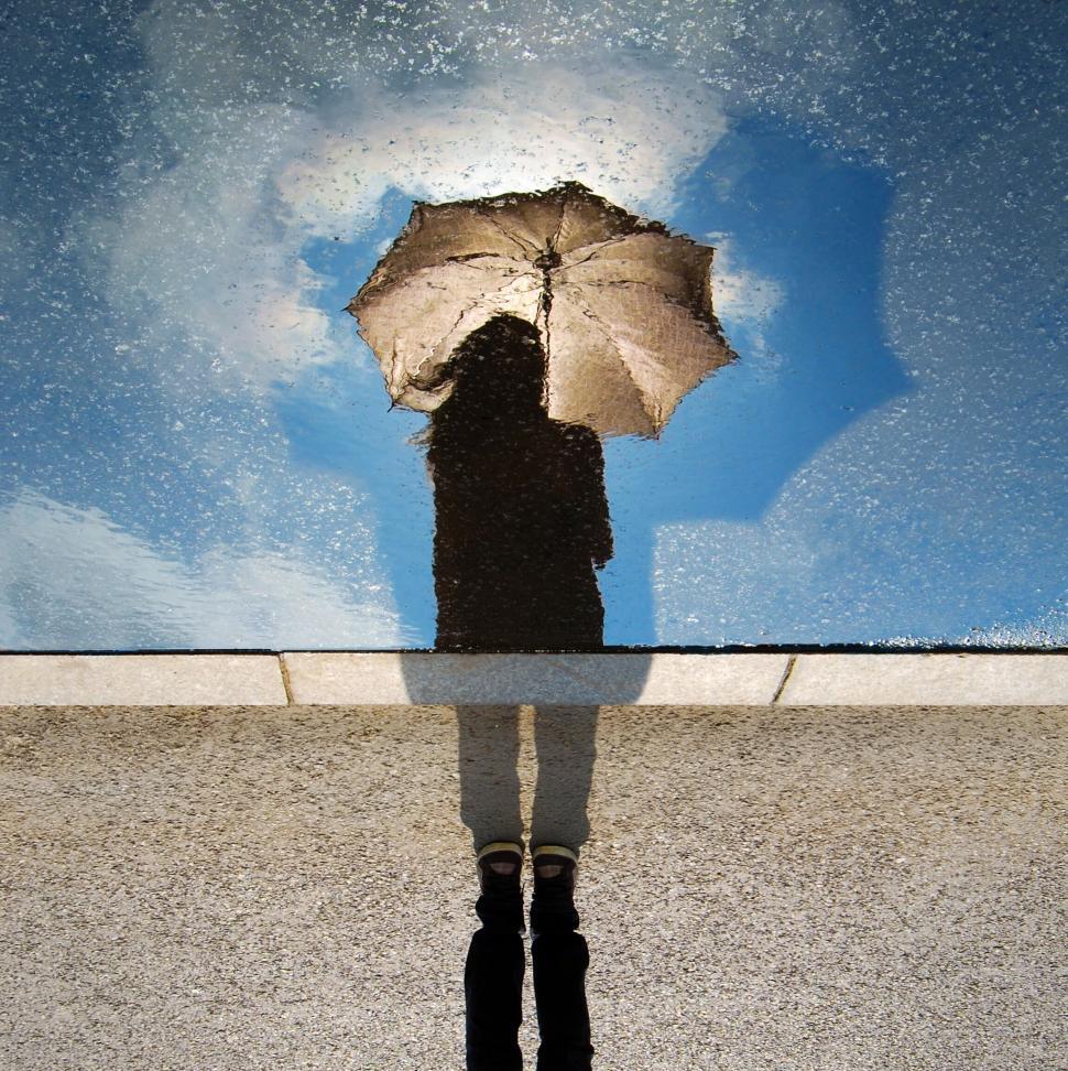 Free Image of Person s reflection standing with an umbrella 