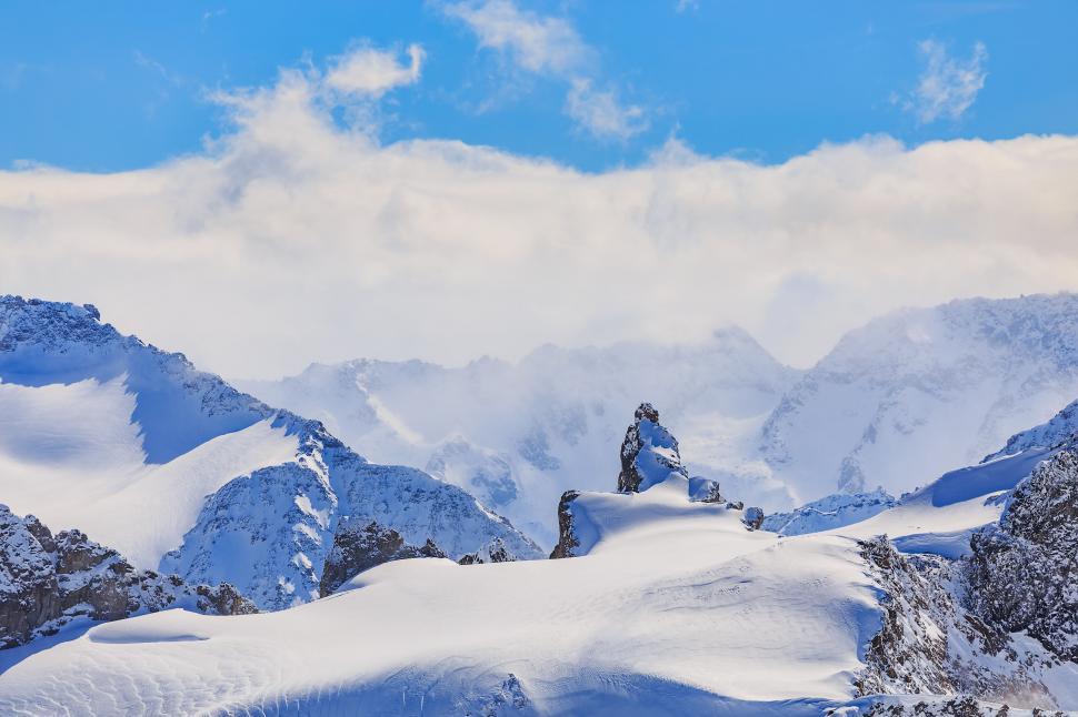 Free Image of Majestic snow-covered mountain peaks and clouds 