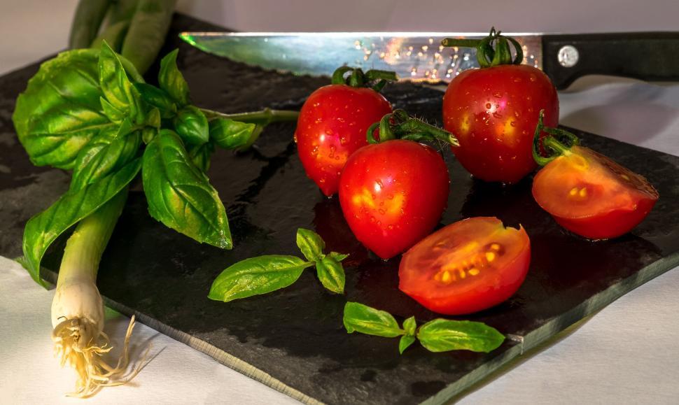 Free Image of Fresh tomatoes and green onions on cutting board 