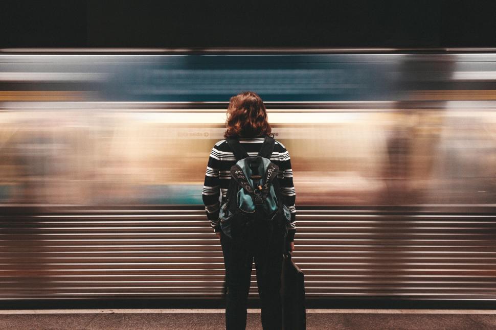 Free Image of Blurry metro train with a woman traveler waiting 