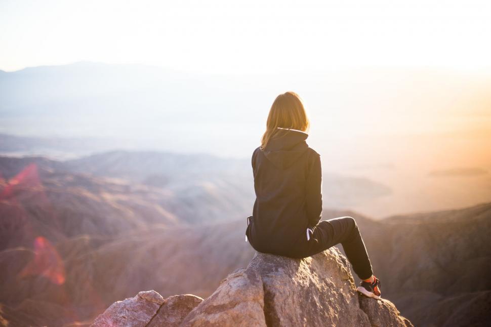 Free Image of Woman contemplating sunset from mountain top 